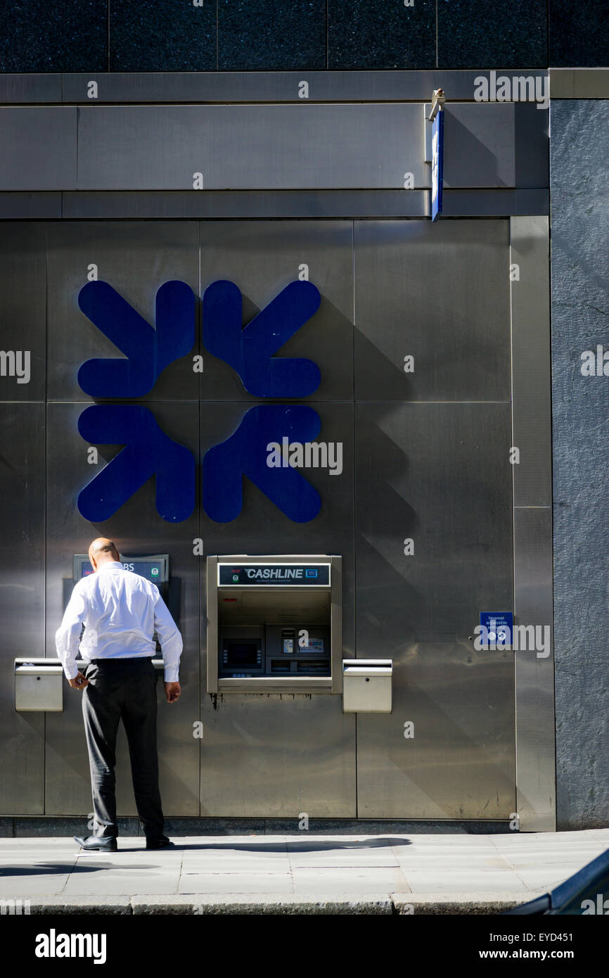 Ein Hemd Ärmel Mann mit einem Royal Bank of Scotland (RBS)-Geldautomat in der City of London UK. Späten Nachmittag Sommersonne. Stockfoto