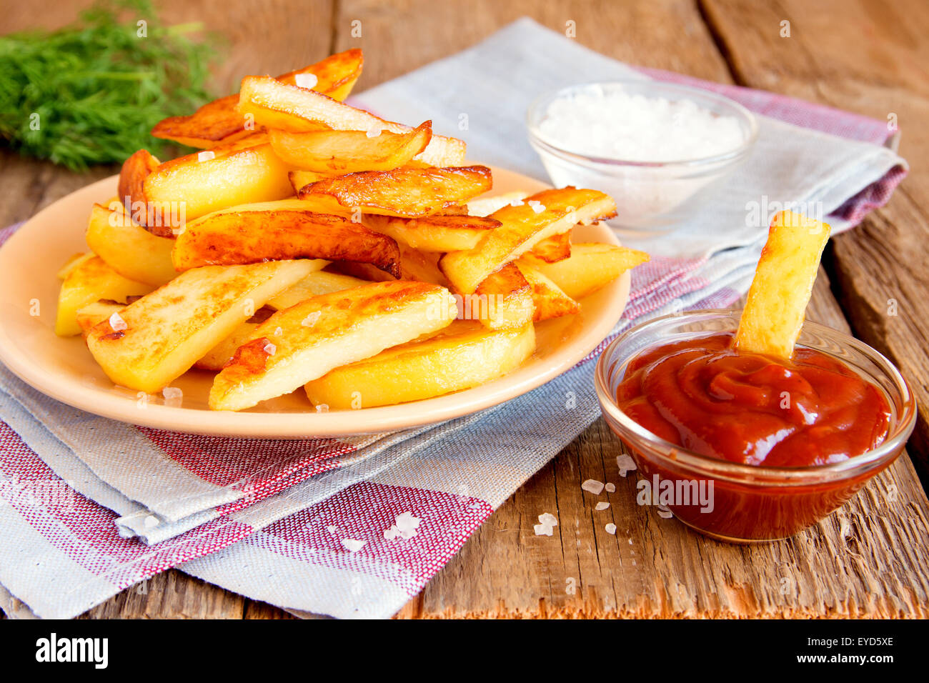 Ketchup-Sauce mit Pommes Frites und Meersalz auf rustikalen Holztisch Stockfoto