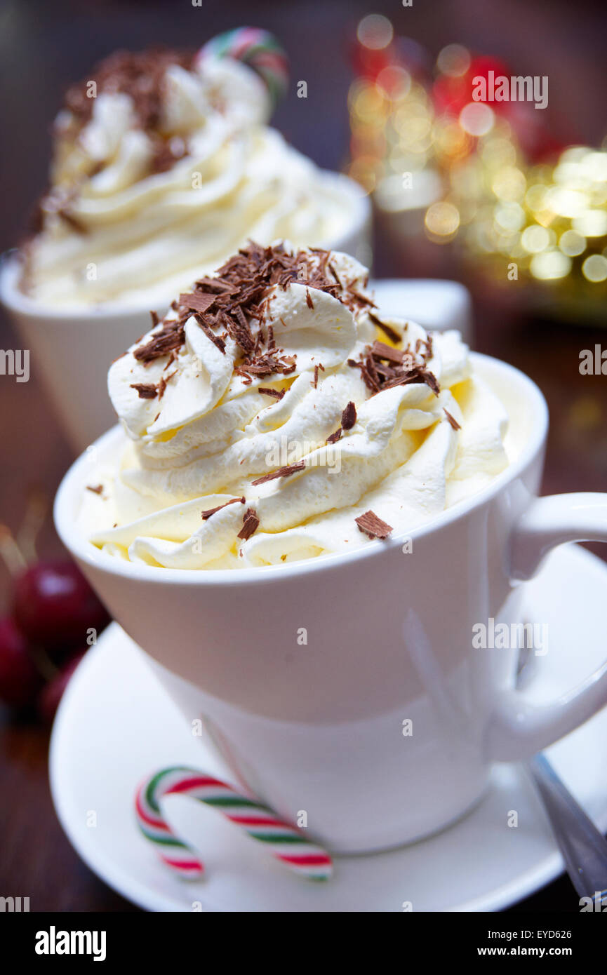 Heiße Schokolade, garniert mit Sahne und Schokolade Streusel mit eine Zuckerstange auf der Seite. Stockfoto
