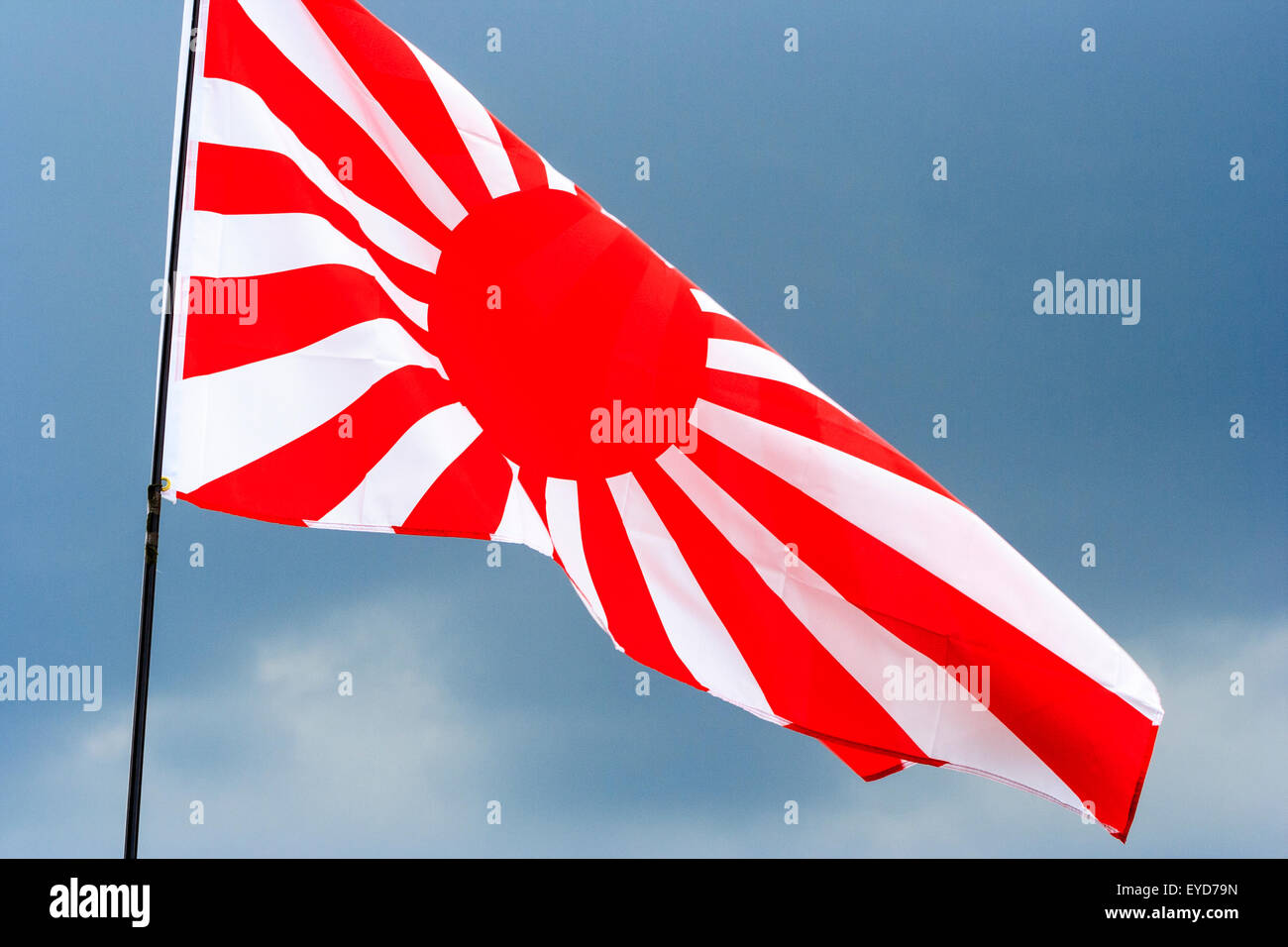 Japanische Rising Sun Flagge, Kyokujitsu-ki, Nisshōki oder Hinomaru, durch das Militär im Zweiten Weltkrieg, dunklen Sturm Wolken im Hintergrund. Stockfoto