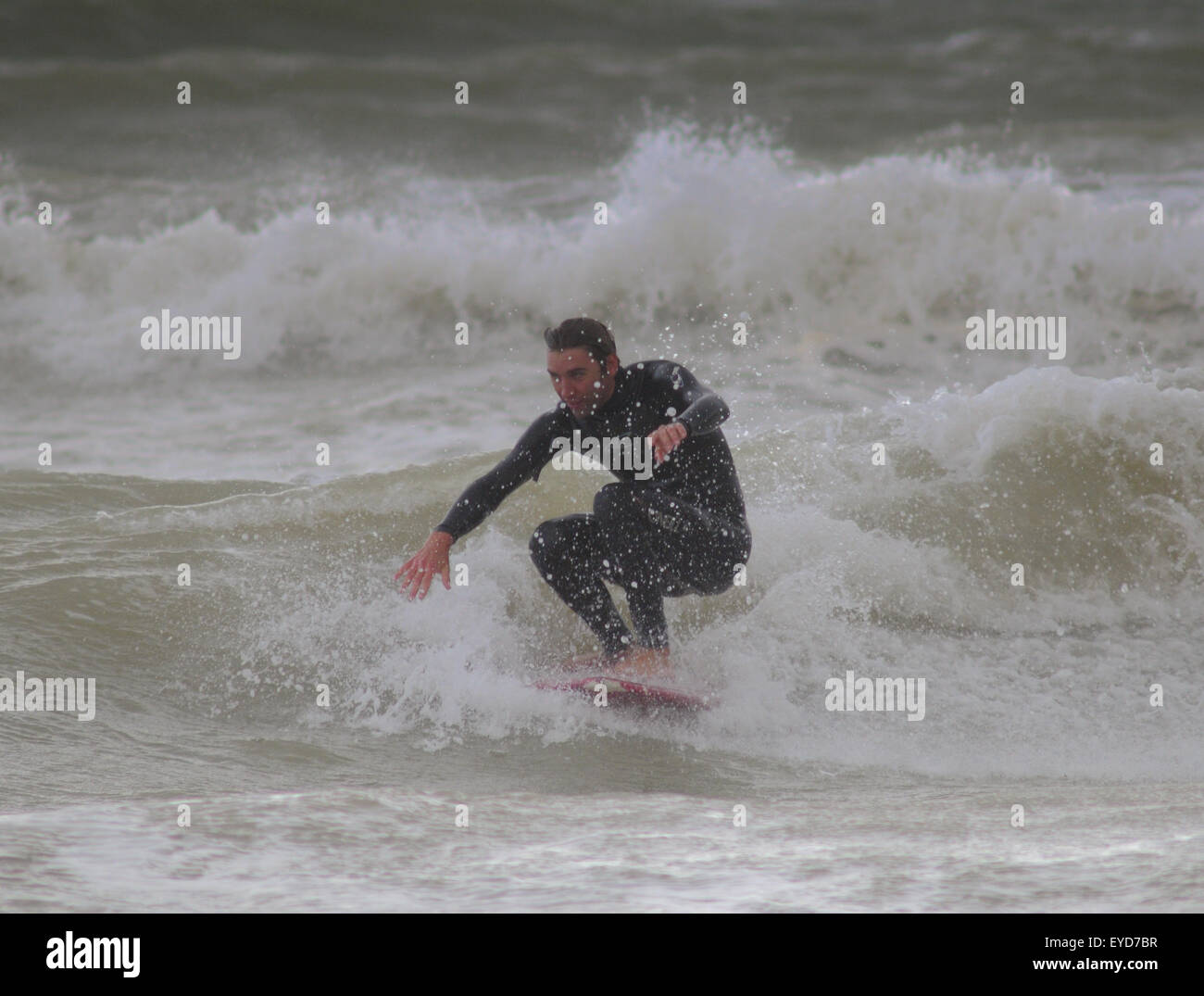 Shoreham, East Sussex, Großbritannien. Juli 2015. Surfer bekommt eine Welle vom Southwick Beach Stockfoto