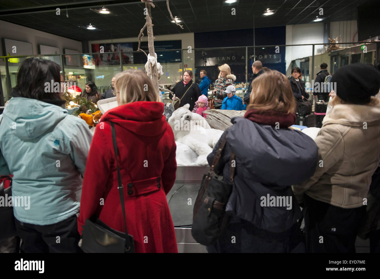 Menschen mit Weihnachtsschmuck In Gepäckhalle am Flughafen Rovaniemi, Levi, Lappland, Finnland Stockfoto