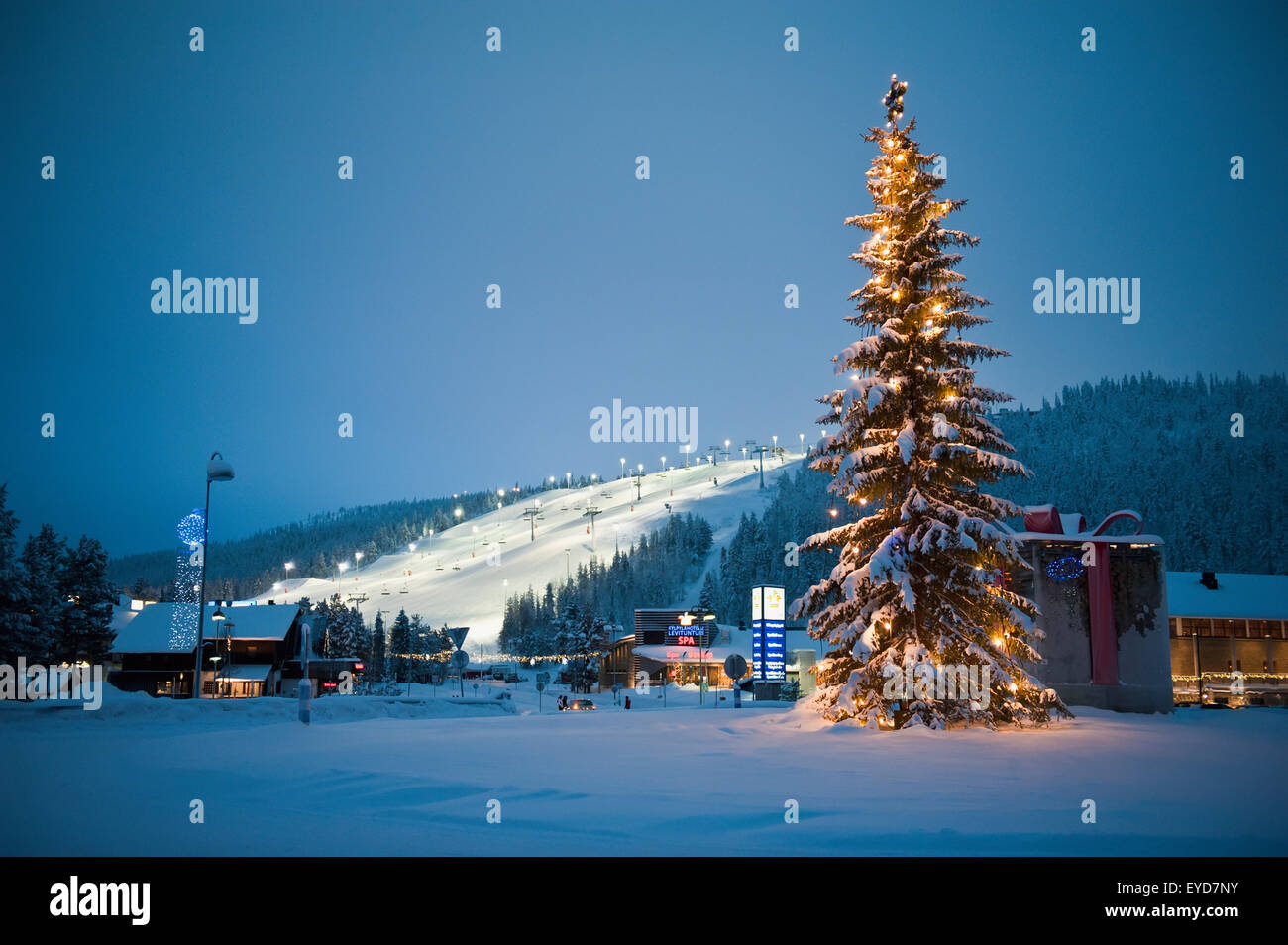Eine große dekorierten Weihnachtsbaum mit Lichter vor dem Flutlicht und Skipisten, Levi, Lappland, Finnland Stockfoto