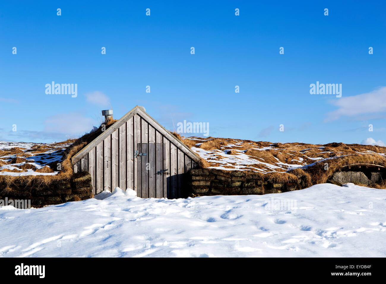 Kleine Hütte mit blauem Himmel im verschneiten Island Stockfoto