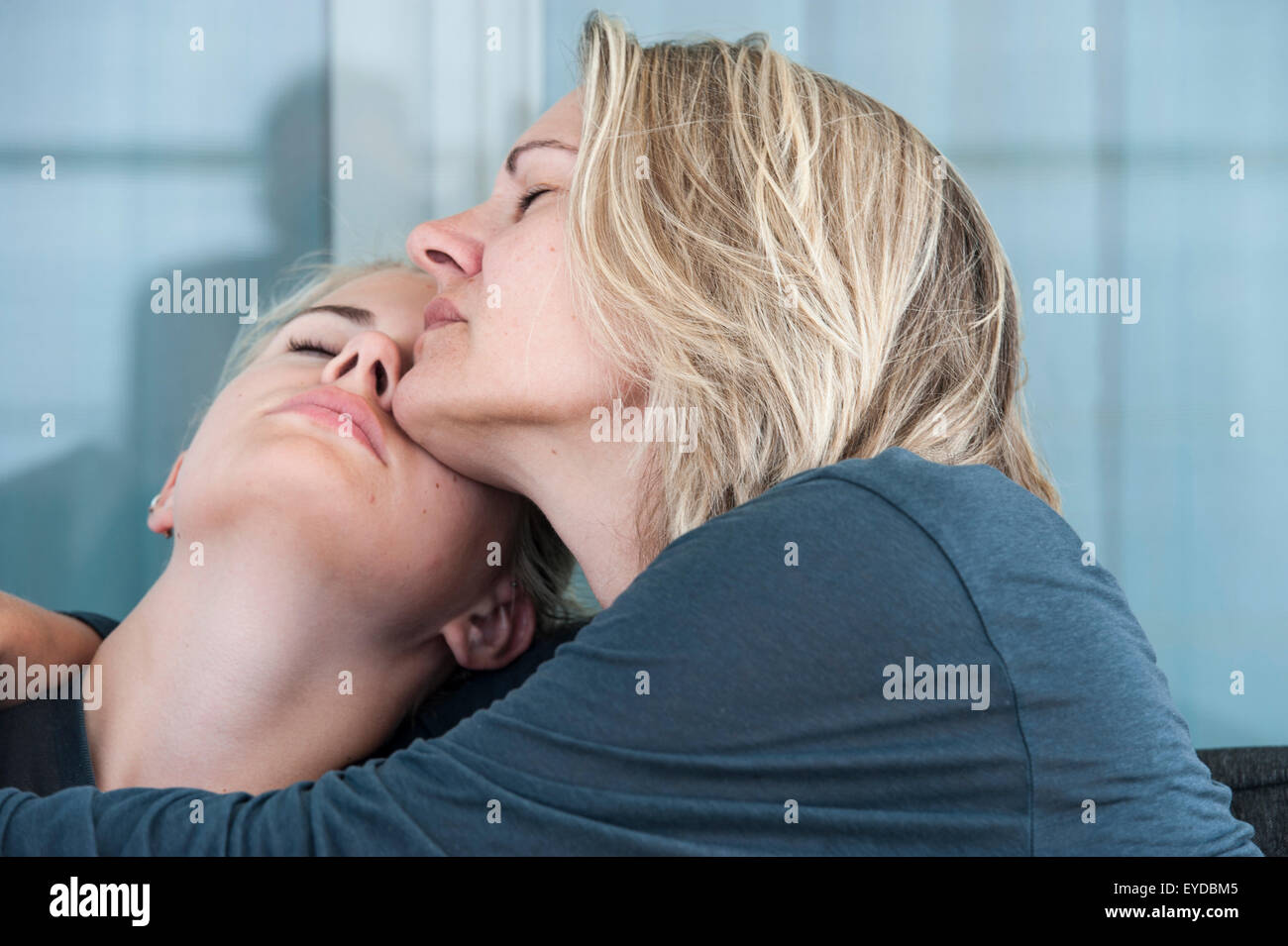 Eine Mutter und Tochter mit ihren Augen umarmen und den liebevollen Moment genießen Stockfoto