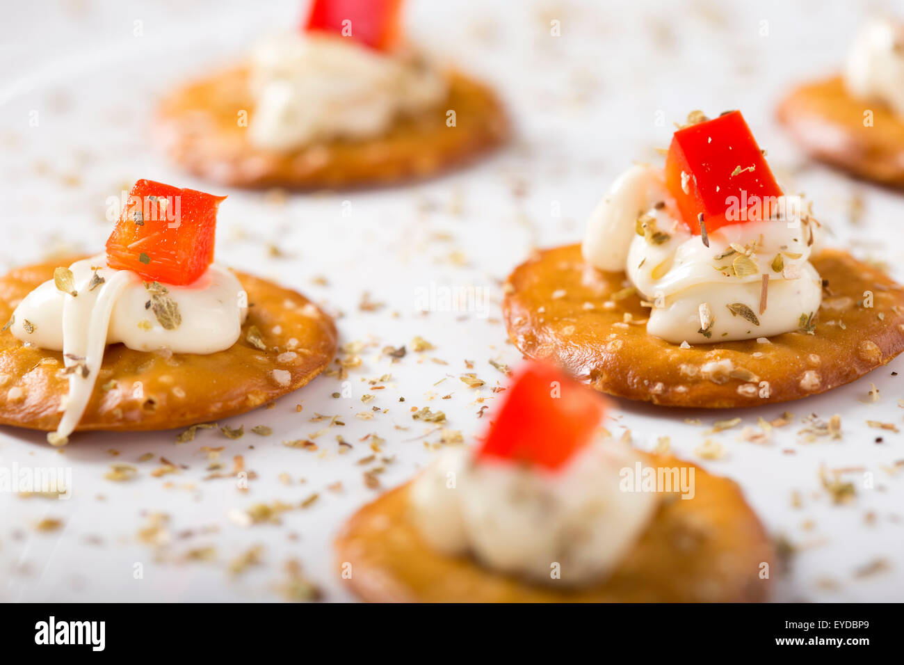 Nahaufnahme von Cracker mit Frischkäse auf einem weißen Teller Stockfoto