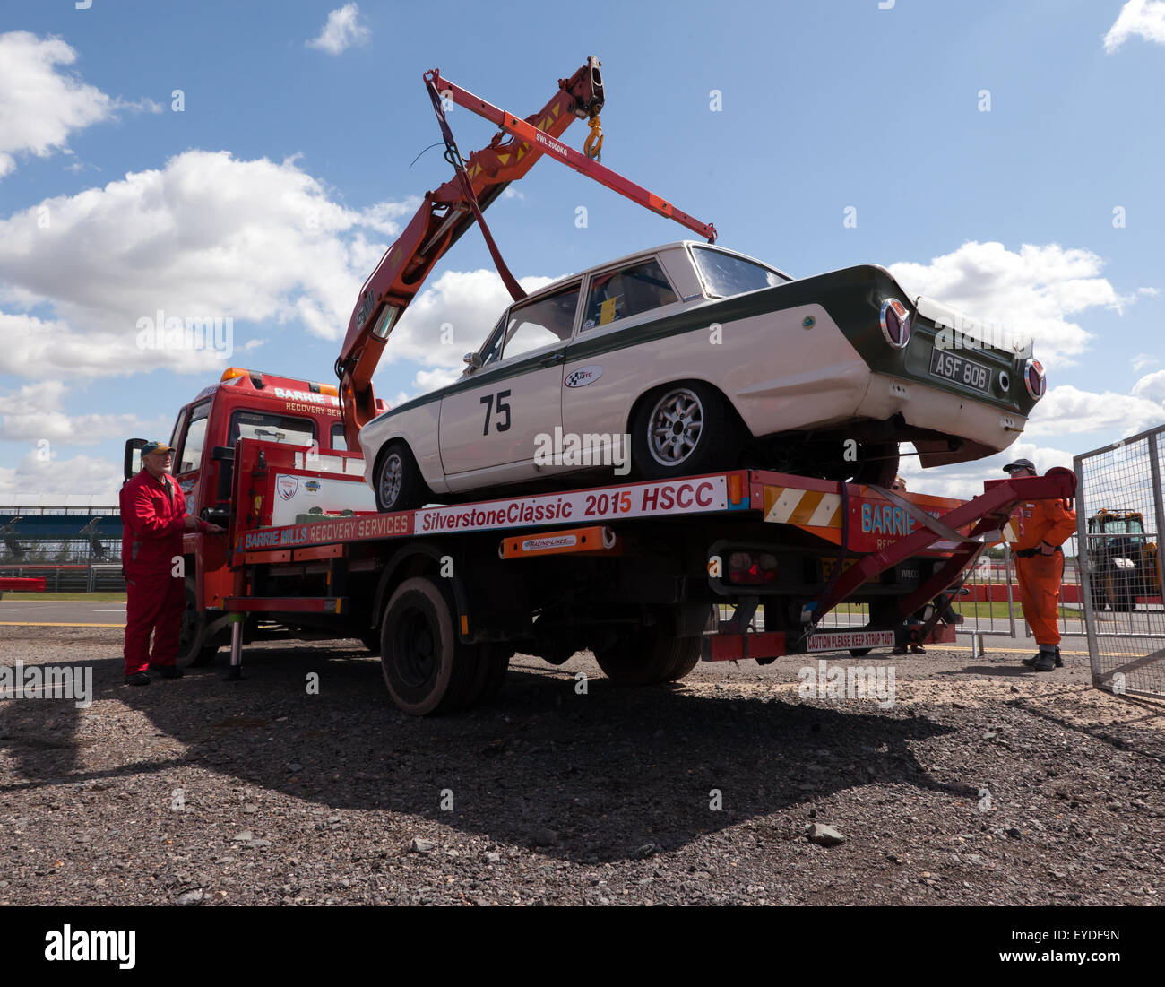 Ein 1965 Ford Lotus Cortina Mk1 mit einem eingestürzten Hinterradfederung auf einen Tieflader bei der Silverstone Classic wiederhergestellt wird. Stockfoto