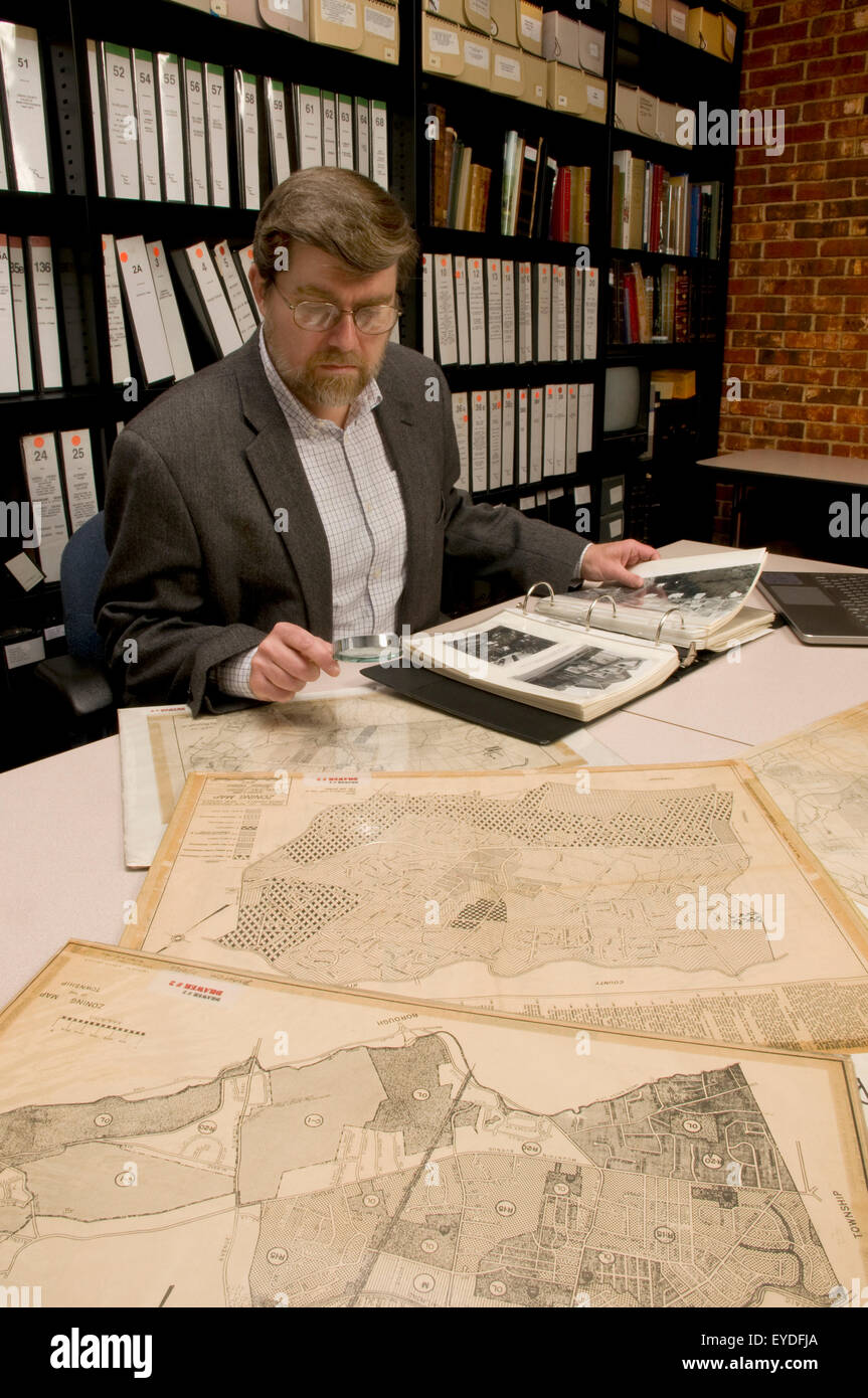 Wissenschaftlicher Mitarbeiter im Archiv, Landkarten und Fotos durchsuchen. -Modell veröffentlicht. Stockfoto