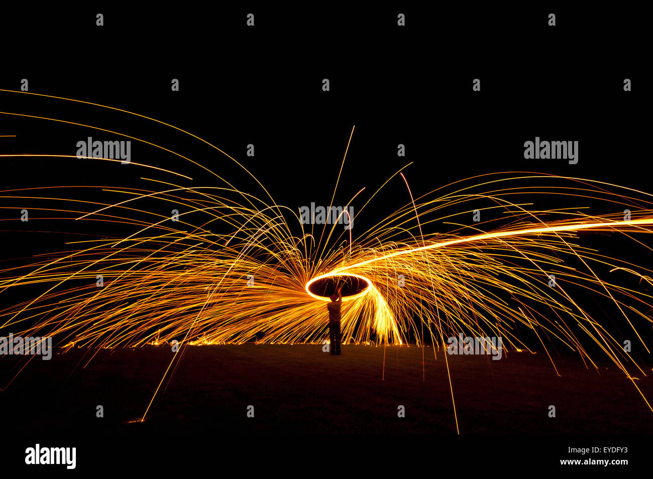 Mann, Spinning Ball der Verbrennung von Stahlwolle auf Nacht, Petersfield, Hampshire, Uk Stockfoto