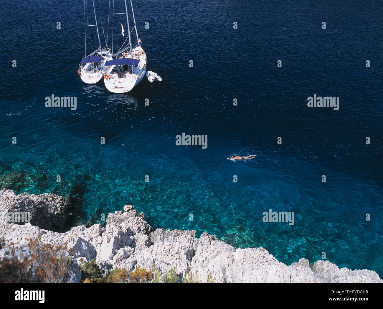 Mann Schnorcheln vorbei an zwei Yachten ankern In der kleinen Bucht auf der Insel Bisevo aus Vis, Kroatien. Stockfoto