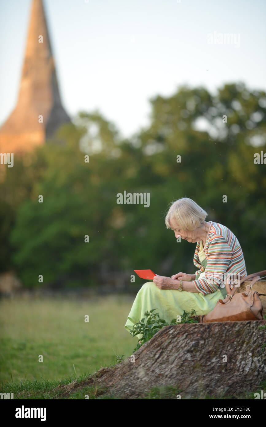 Oma mit ihrem Ipod auf dem Lande. Stockfoto