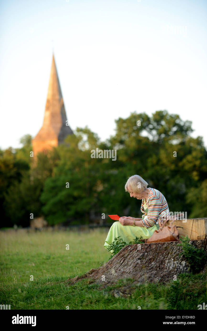 Oma mit ihrem Ipod auf dem Lande. Stockfoto