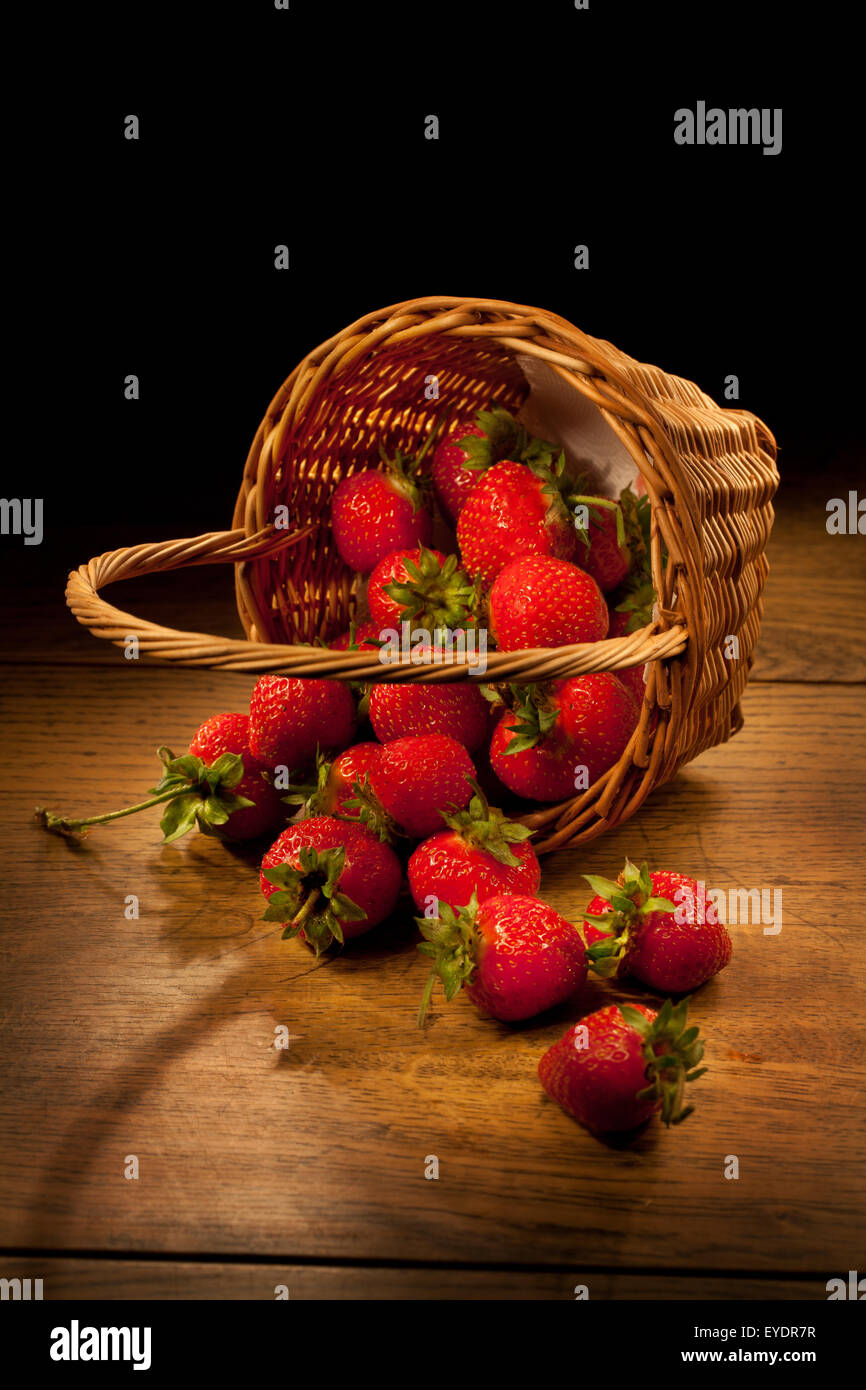 Stillleben des ländlichen Raums Essen Beerenfrucht Tabelle Gruppe Licht Pinsel Holz alten Retro-Stil Produkt Erdbeere Korb Korbwaren rot Stockfoto