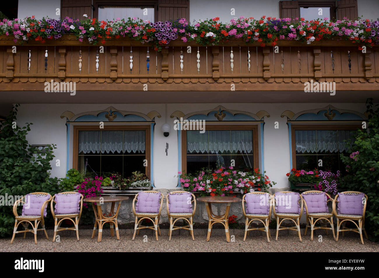 Rosa Kissen auf Wicker Sitzplätze im Freien ein ländliches Hotel in den Dolomiten Stadt von Badia-Abtei, Italien. Stockfoto