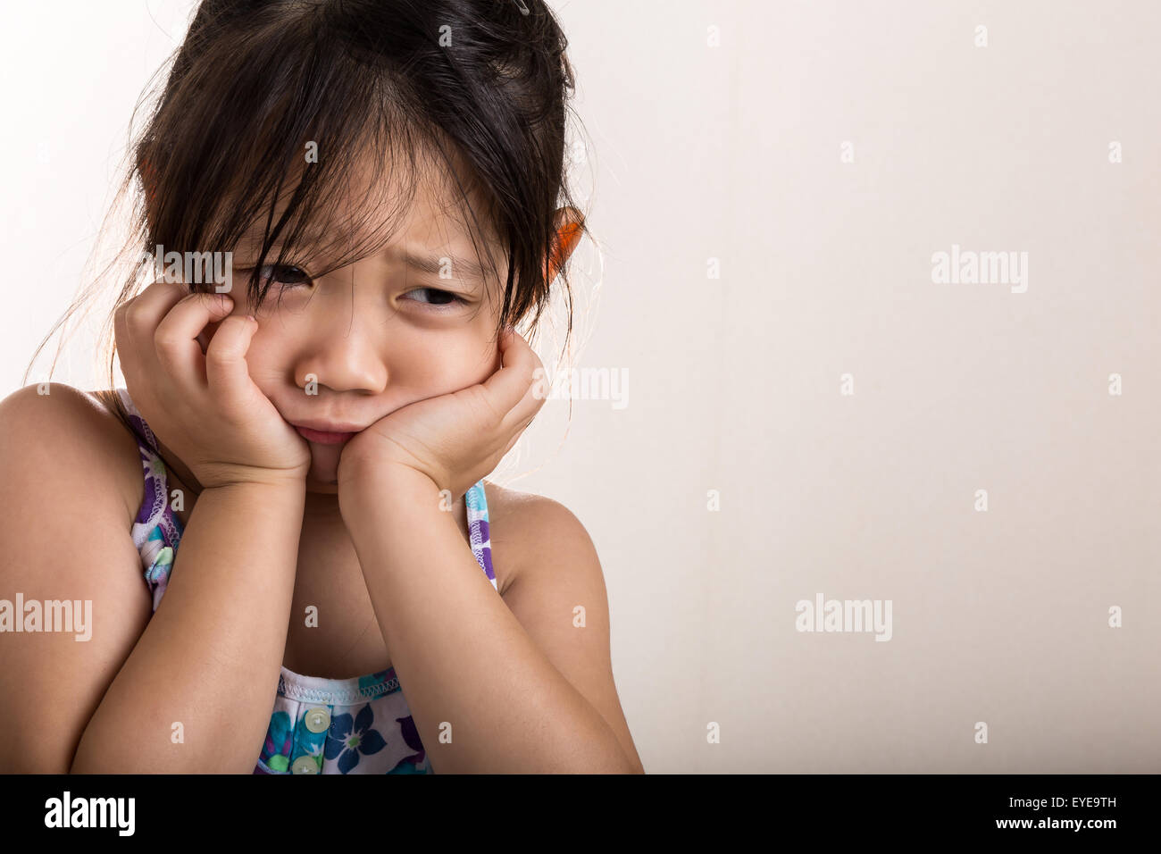 Trauriges kleines Mädchen auf weißem Hintergrund isoliert. Stockfoto
