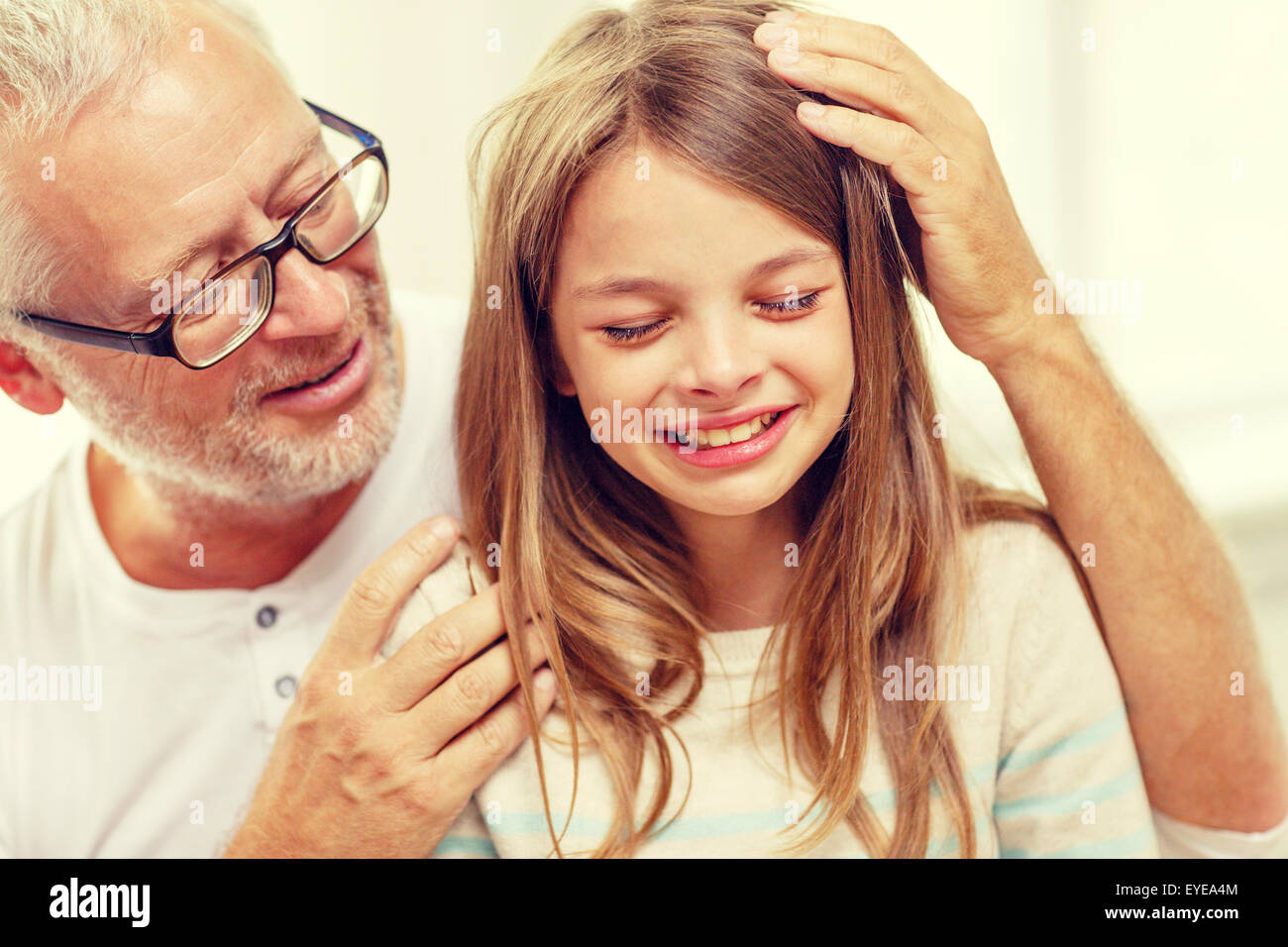 Großvater mit Weinen Enkelin zu Hause Stockfoto