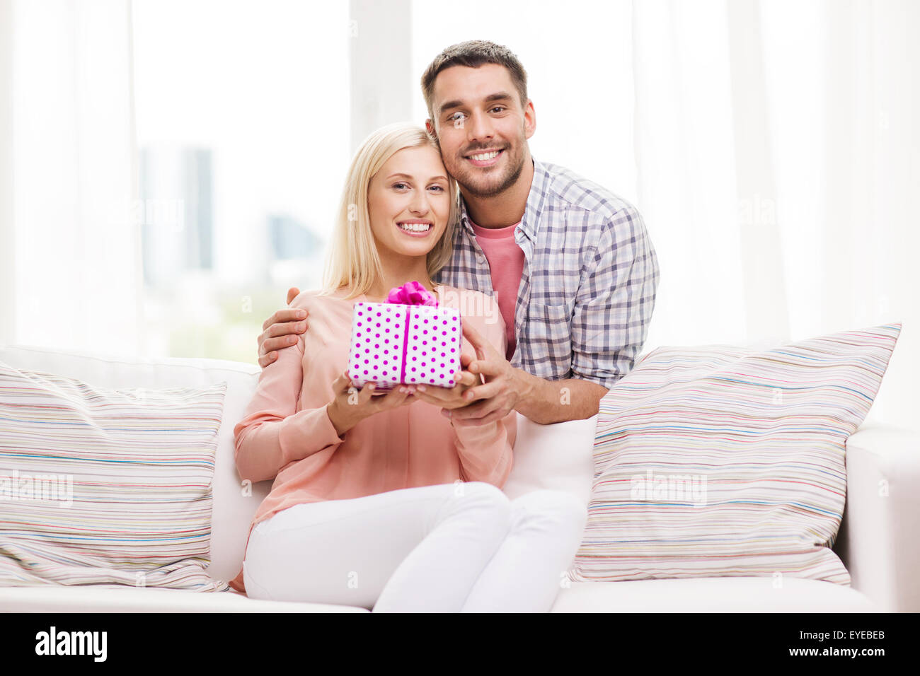 glücklicher Mann geben Frau Geschenk-Box zu Hause Stockfoto