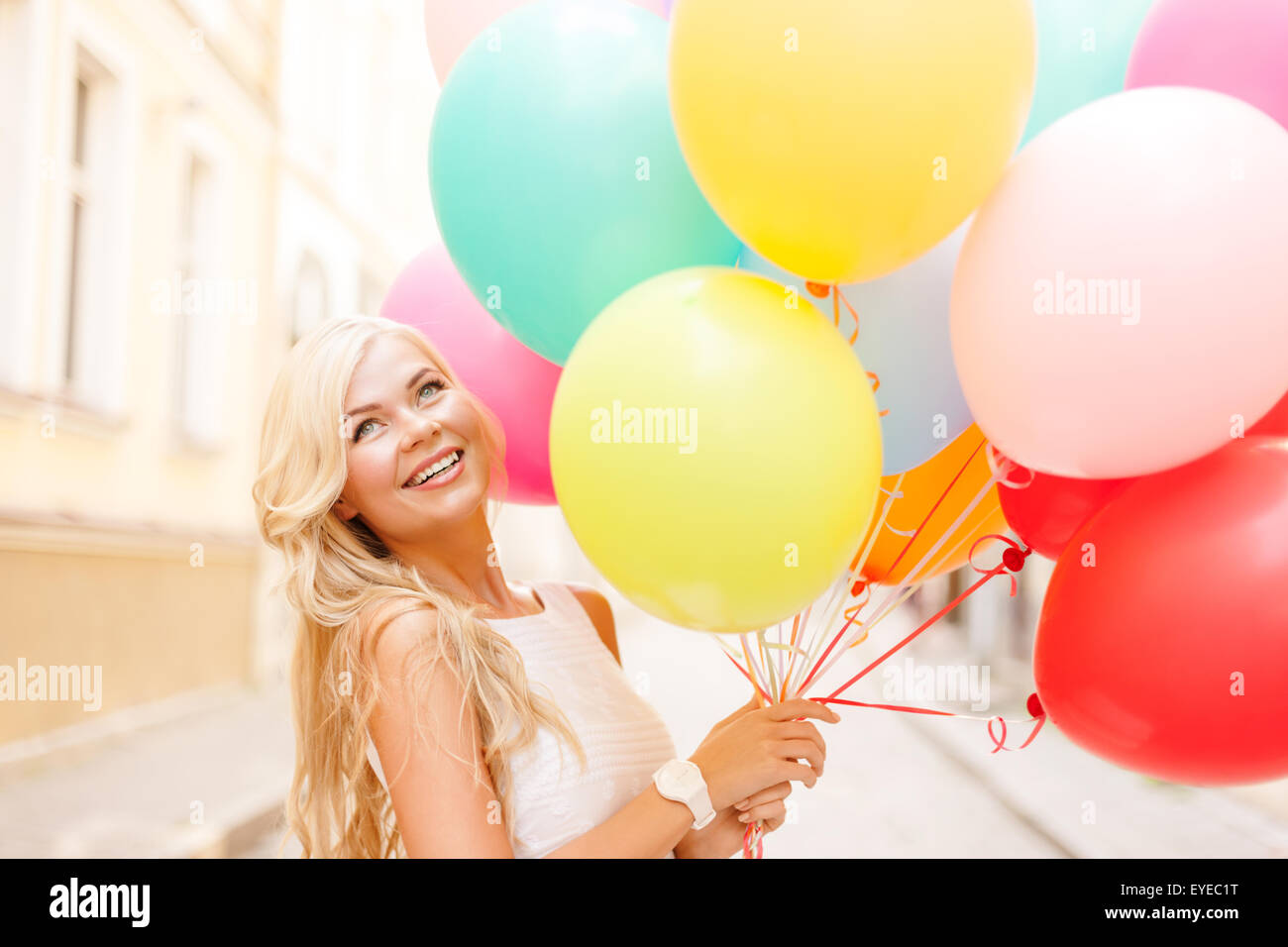 lächelnde Frau mit bunten Luftballons Stockfoto