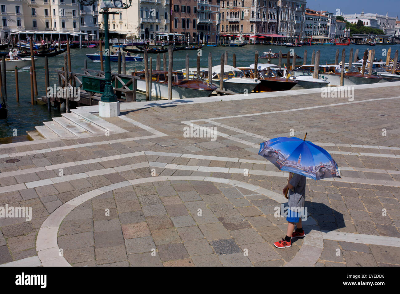 Ein Junge trägt einen Venedig-Bild-Schirm vor Santa Maria della Salute Kirche in Dorsoduro, mit Blick auf den Canal Grande Stockfoto
