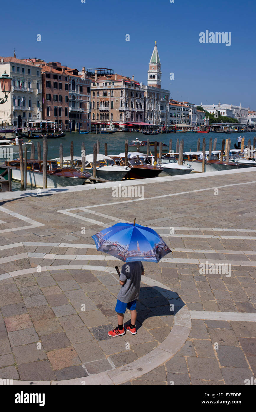 Ein Junge trägt einen Venedig-Bild-Schirm vor Santa Maria della Salute Kirche in Dorsoduro, mit Blick auf den Canal Grande Stockfoto