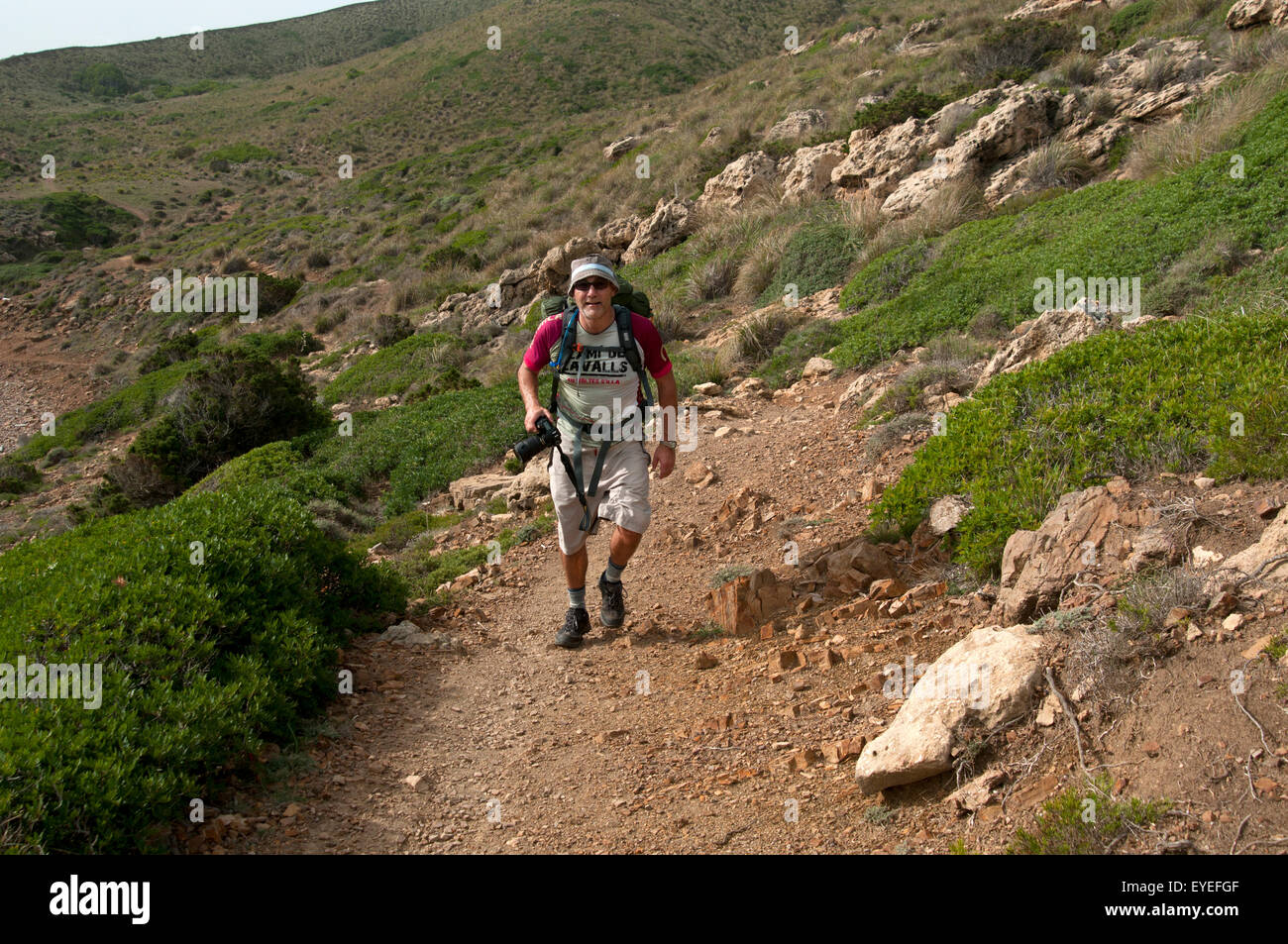 Ein Wanderer geht entlang einer felsigen nördlichen Küste der Braut Cami de Cavalls Trail auf der Insel Menorca Spanien Stockfoto