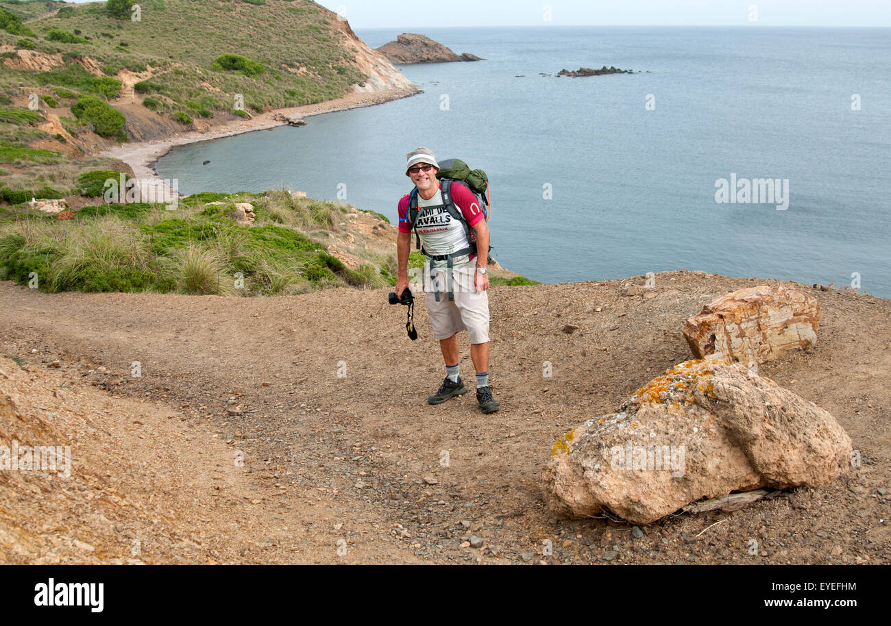 Ein Wanderer geht entlang einer felsigen nördlichen Küste der Braut Cami de Cavalls Trail auf der Insel Menorca Spanien Stockfoto