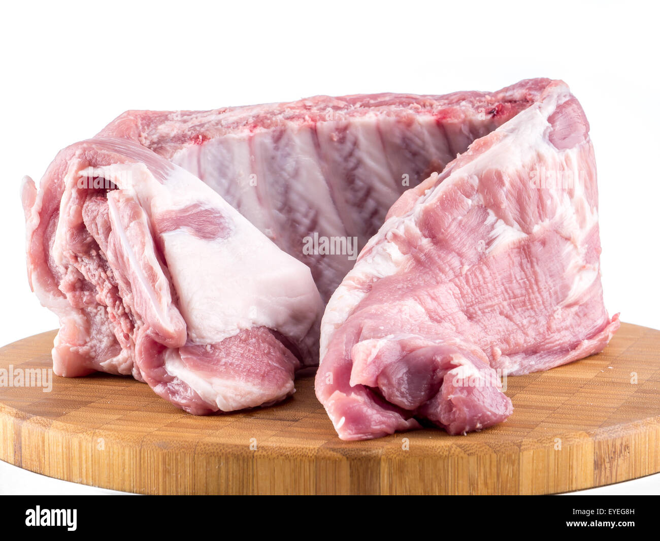 Rohe Schweinerippchen auf Holzbrett auf weißem Hintergrund Stockfoto