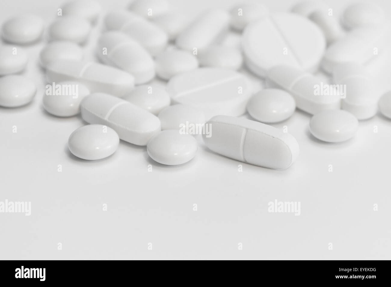 viele weiße Pillen / Tabletten auf weißem Hintergrund Stockfoto