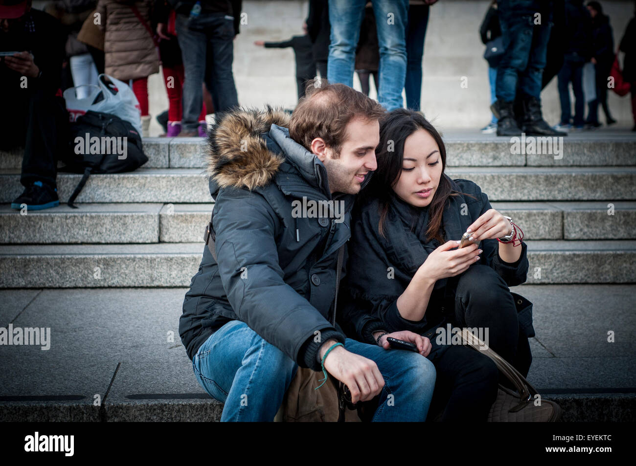 Junges Paar Blick auf Handy, London, UK Stockfoto