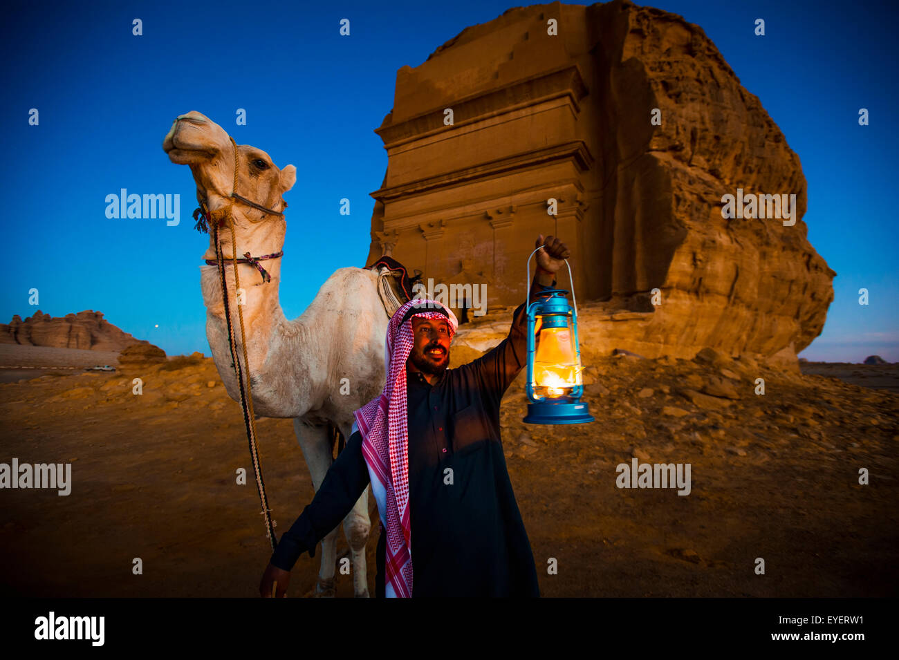 Kamel und Fahrer mit Madain Saleh im Hintergrund; Madain Saleh, Saudi-Arabien Stockfoto