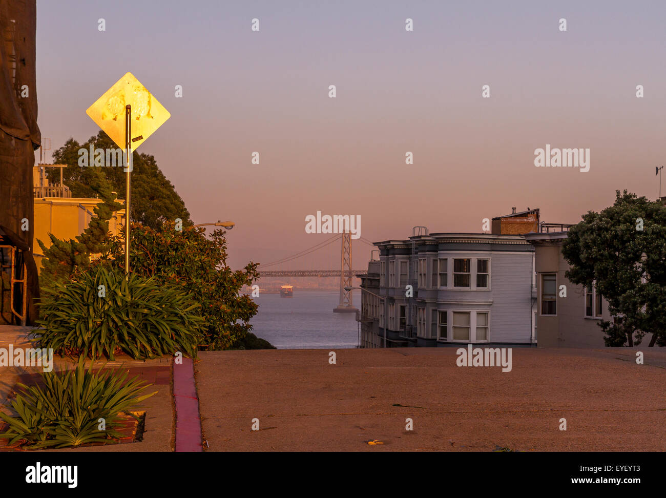 Die Oakland Bay Bridge in der Ferne von der Spitze eines steilen Hügels in North Beach, San Francisco, Kalifornien Stockfoto