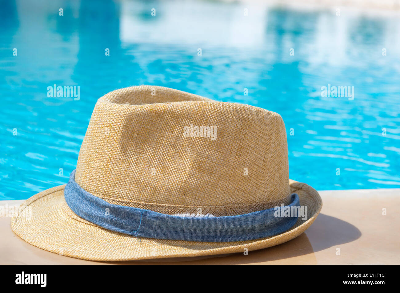 Strohhut mit blauen Band am Pool Stockfoto