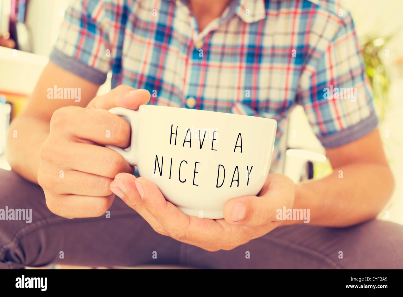 Nahaufnahme eines jungen Mannes mit einer Tasse Kaffee oder Tee in der Hand mit dem Text noch einen schönen Tag geschrieben Stockfoto