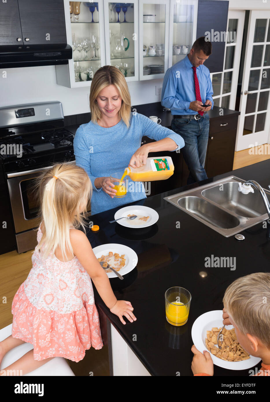 Eltern mit Tochter (2-3) und Sohn (8-9) während des Frühstücks Stockfoto
