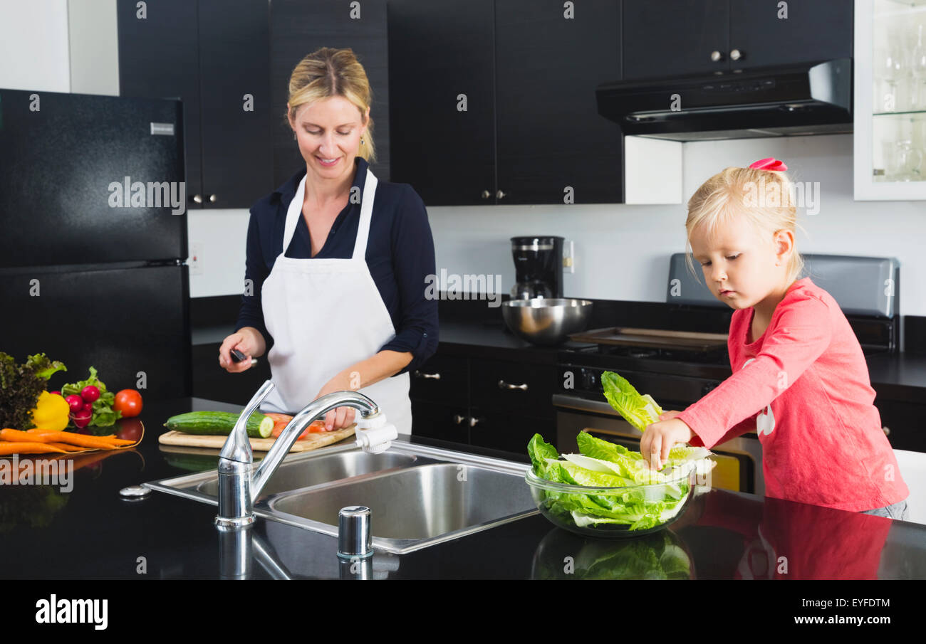 Mutter mit Tochter (2-3) Vorbereitung Essen Stockfoto