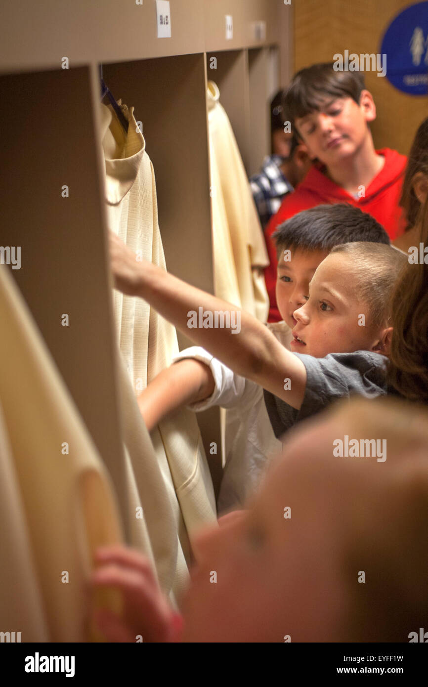 In der Sakristei des Laguna Niguel, CA, katholische Kirche untersuchen multirassische Kind Gemeindemitglieder Priester Gewänder in Vorbereitung auf die Erstkommunion, auch bekannt als Heilige Eucharistie. Stockfoto