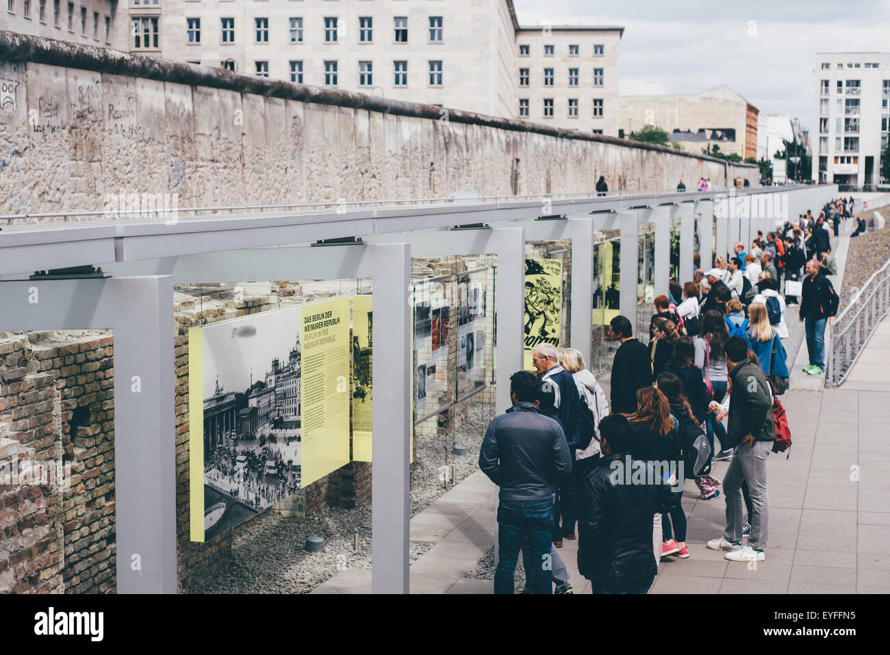 Lesung auf Geschichte an der Topographie des Terrors mit der Berliner Mauer hinter Touristen. Stockfoto
