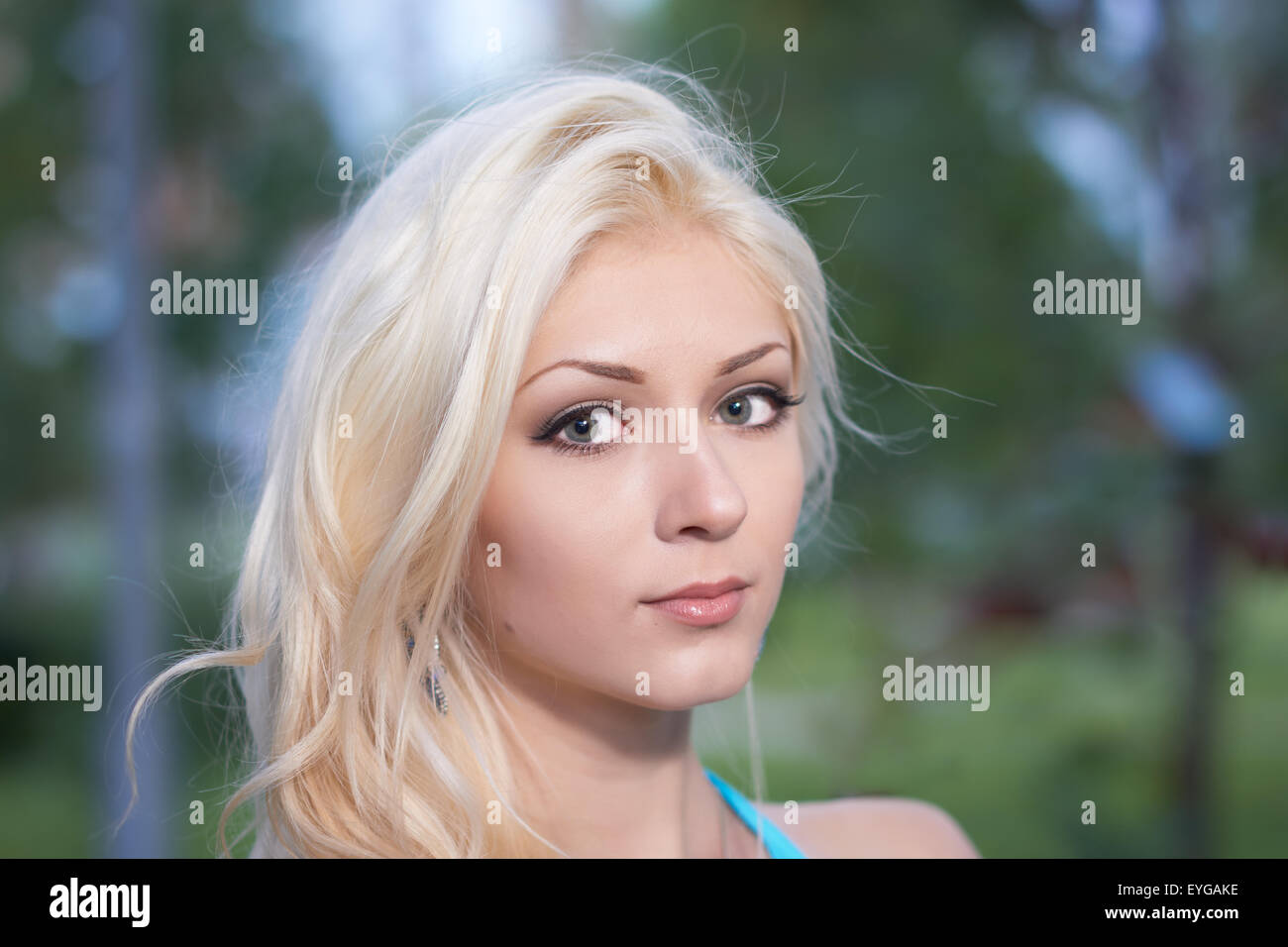 Porträt des schönen Mädchens auf dem grünen verschwommenen Hintergrund der Sommerpark Stockfoto