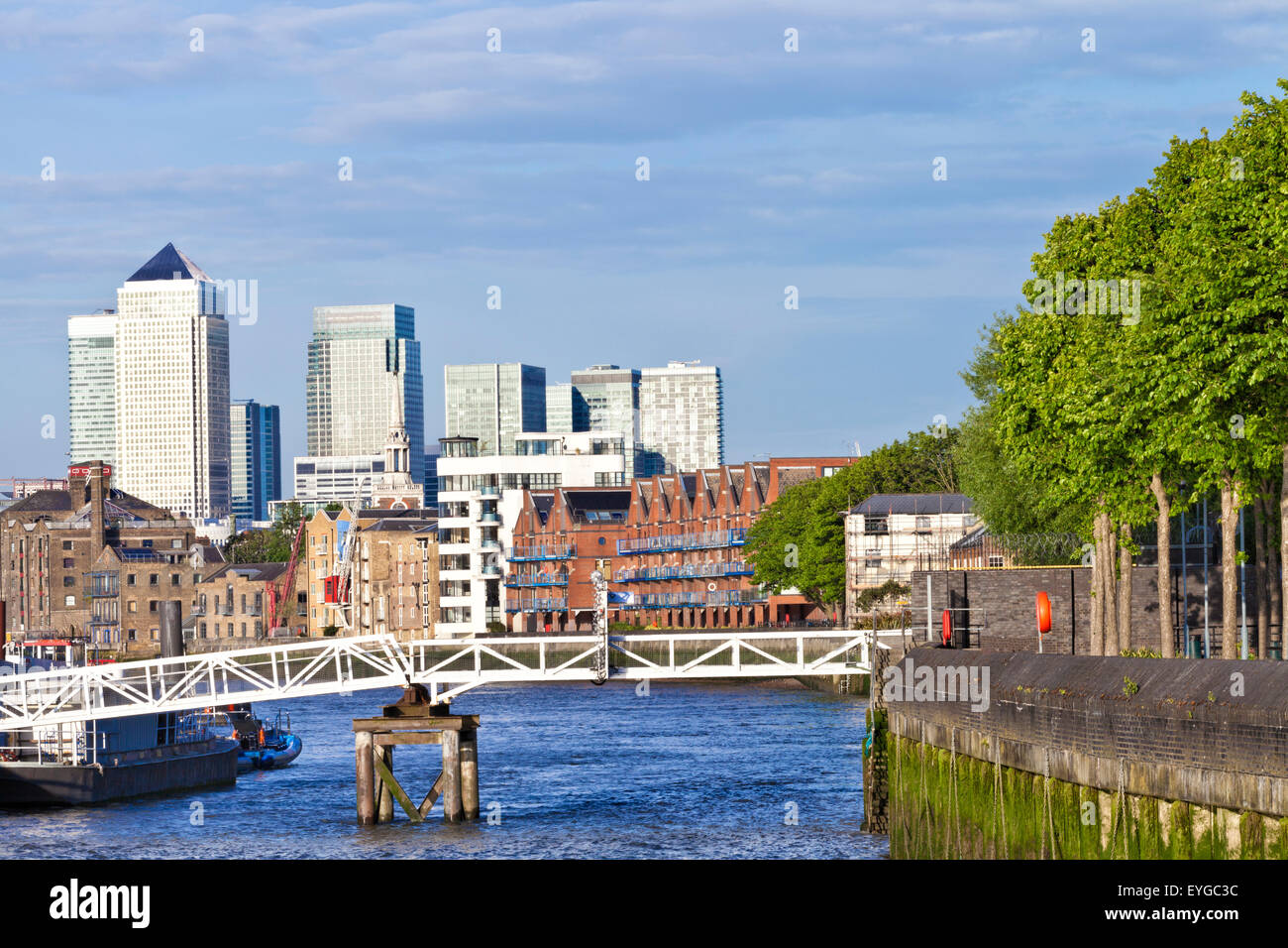 London Canary Wharf Docklands Skyline-Blick auf die Themse entlang Bankside mit grünen Bäumen, Häuser am Wasser im Spätsommer Stockfoto