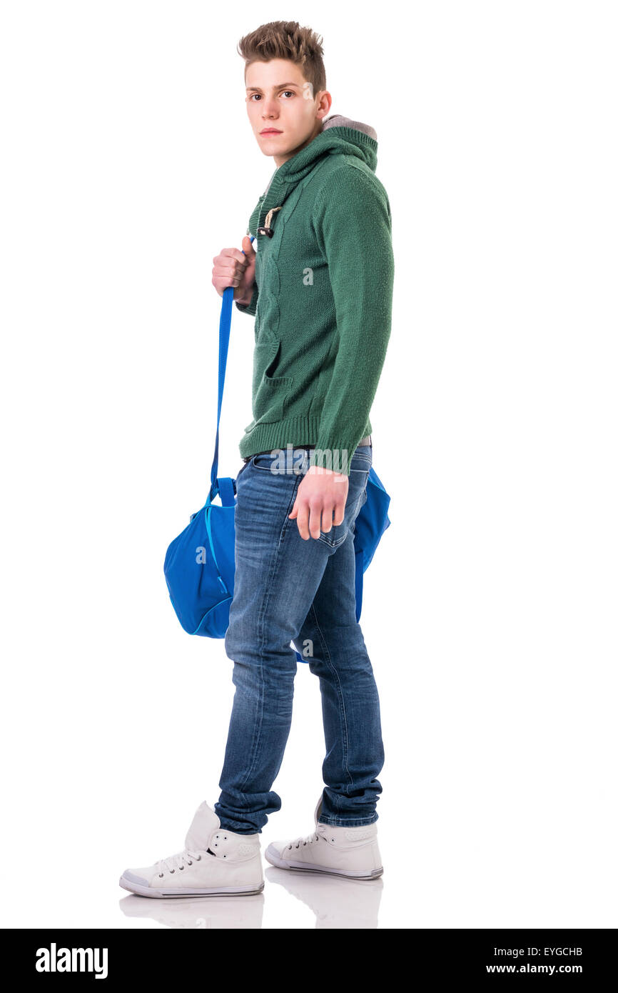 Attraktive trendige jungen Mann mit Tasche am Schultergurt, isoliert auf weißem Hintergrund, zu Fuß nach links, Blick in die Kamera Stockfoto