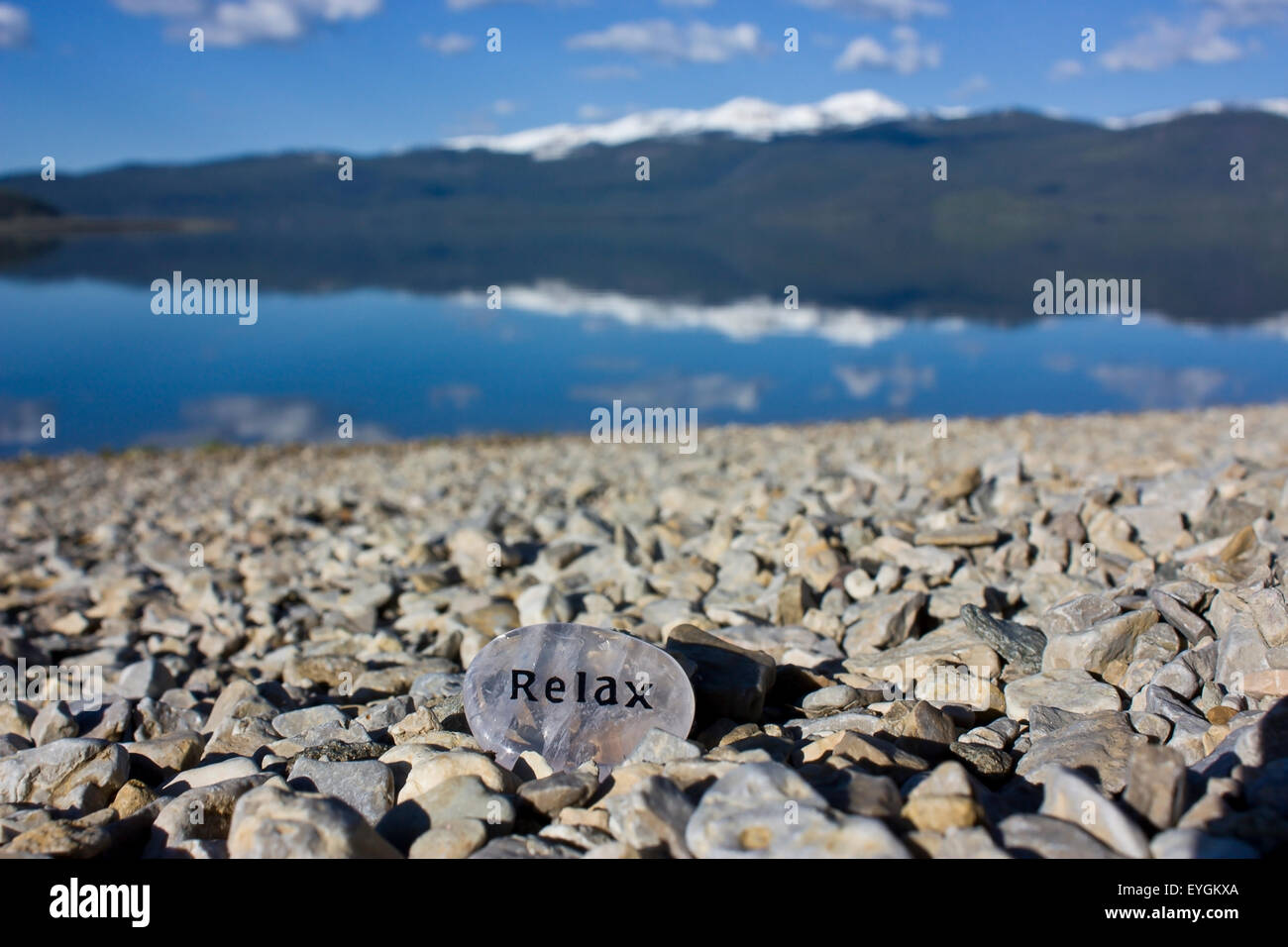 Rock mit dem Wort entspannen an einem ruhigen Morgen, wo der See ist so glatt wie, geätzt hinein an einem steinigen Strand am Hebgen Lake Montana Stockfoto