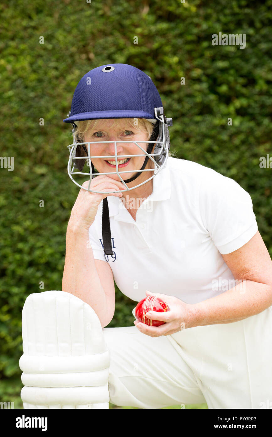 Porträt einer Seniorin Cricket-Spieler tragen ein Batswomans Helm mit Gesichtsschutz Stockfoto