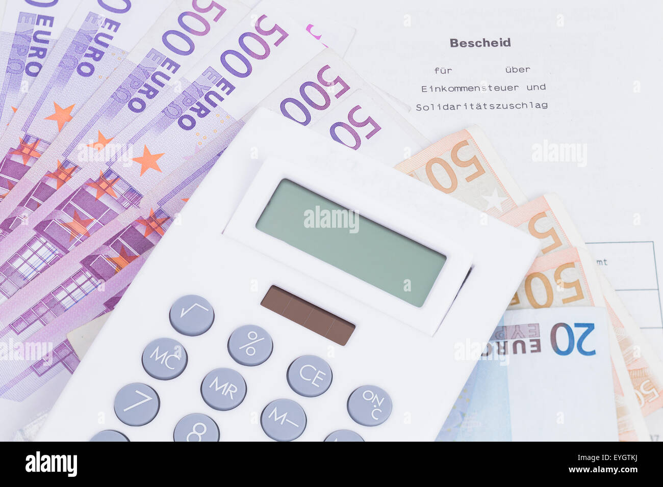 Bild zeigt einen Steuerbescheid mit Geld und Rechner Stockfoto