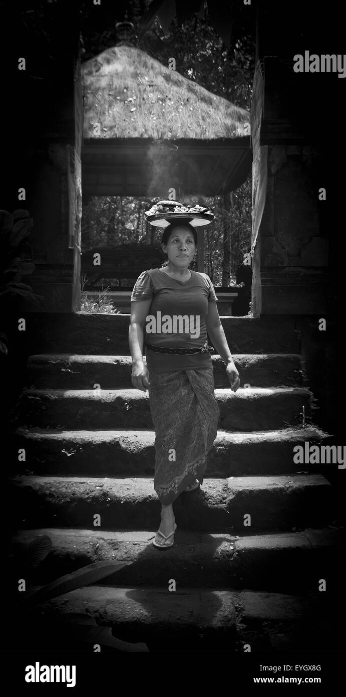Frau, die die Platte mit warmen Speisen auf Kopf; Ubud, Bali, Indonesien Stockfoto