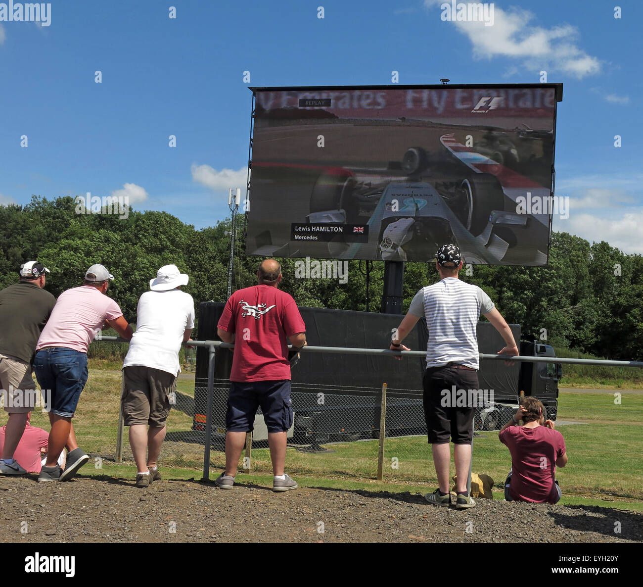 Silverstone F1 British Grand Prix GP England, Fans, die sich Lewis Hamilton auf einem großen LCD-Bildschirm ansehen Stockfoto