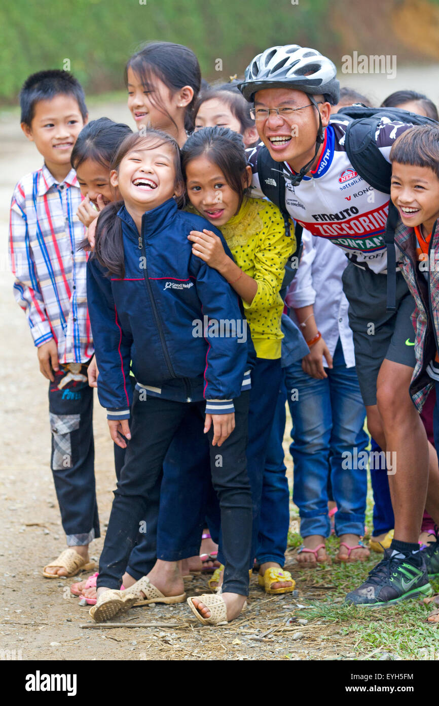 Radfahrer bei Schulkindern auf einer Straße in der Nähe von Cuc Phuong Nationalpark Stockfoto