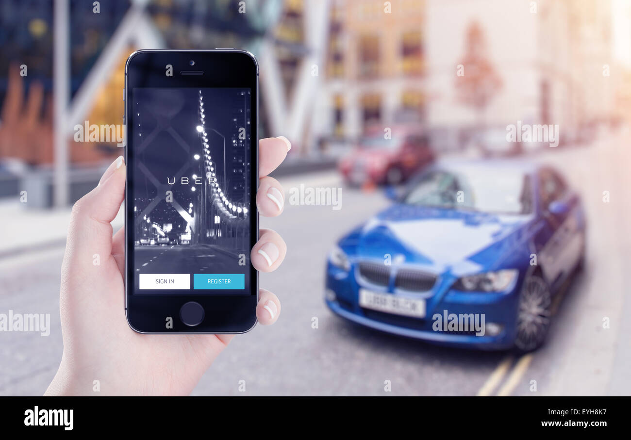 Varna, Bulgarien - 25. Mai 2015: Uber Anwendung Startseite auf Apple iPhone in weiblicher Hand. Straßenansicht im Hintergrund unscharf. Stockfoto