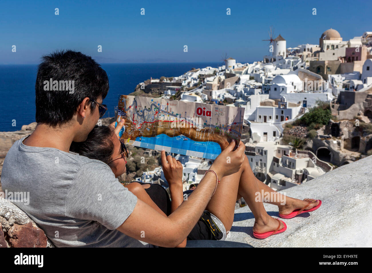 Junge asiatische Menschen mit einer Dorfkarte Oia Santorini Touristen Paarliebhaber, griechische Insel, Griechenland reisen Europa Touristen Stockfoto