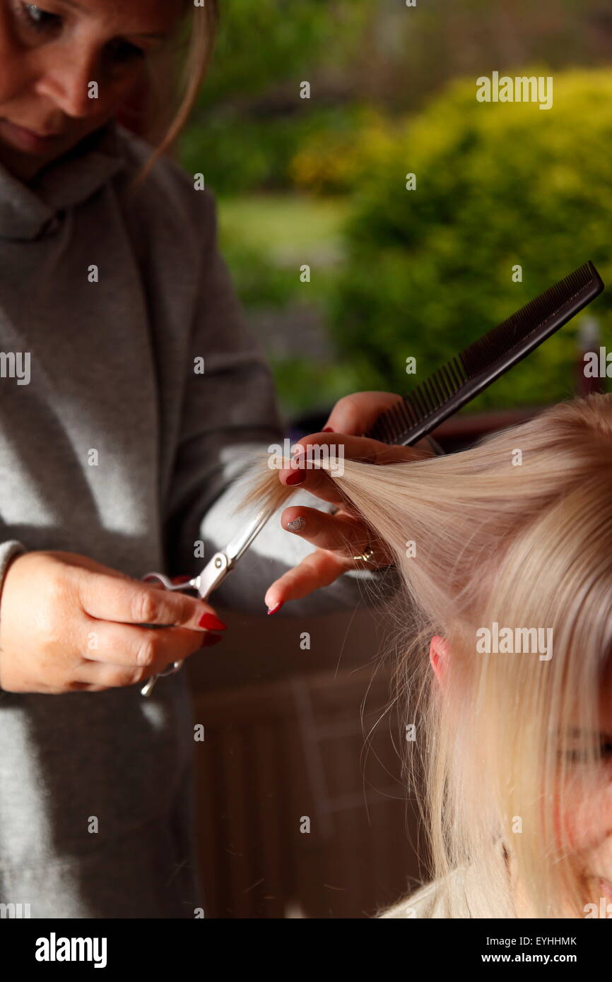 Frau erhält einen neuen Haarschnitt in ihrem Haus in Oldham, Großbritannien Stockfoto