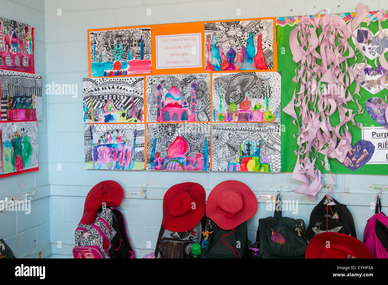 Garderobe für die australische Grundschule, rote Hüte und Schultaschen in einem Umkleideraum für die Grundschule in Sydney, NSW, Australien mit Kinderkunst Stockfoto